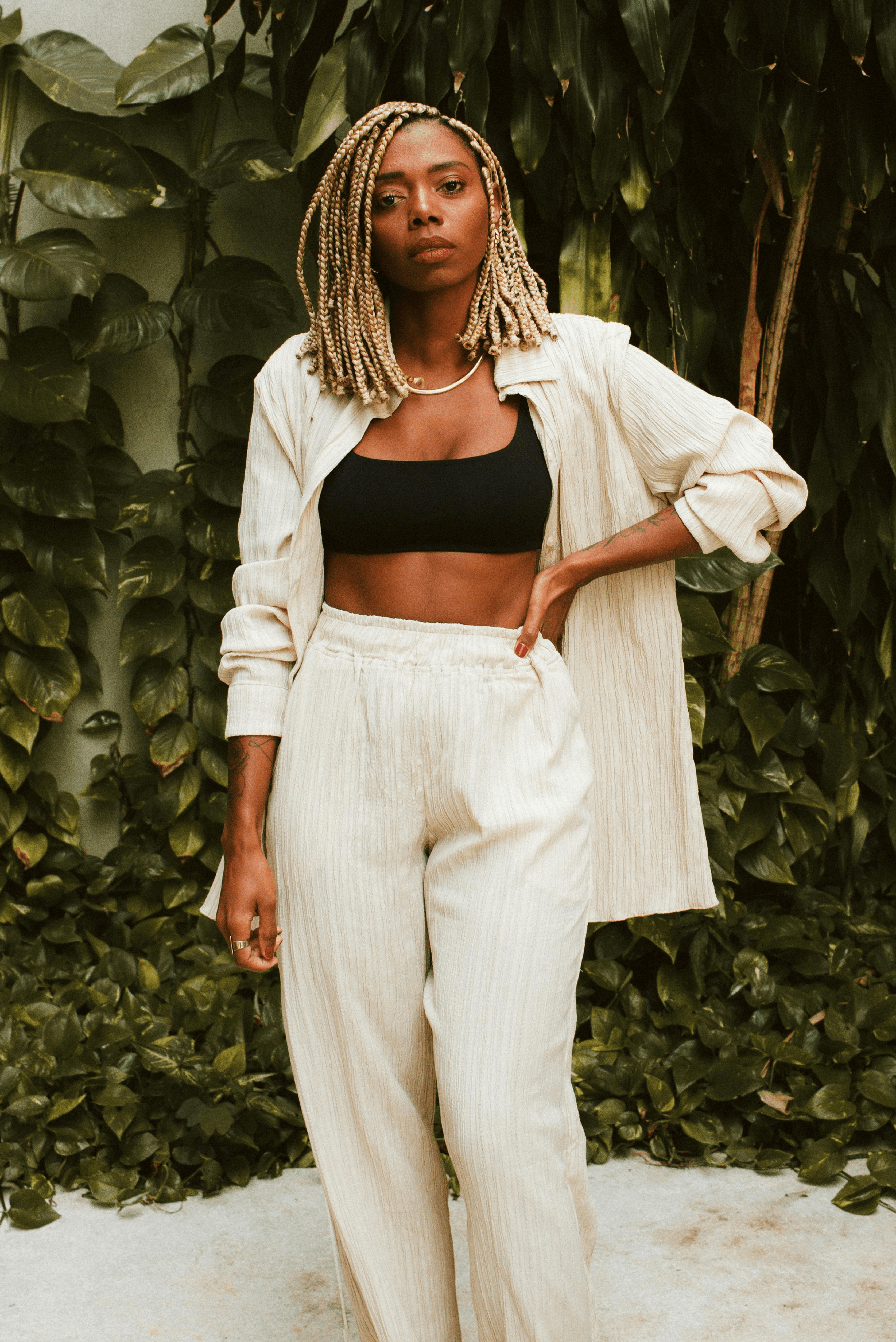 Woman wearing a neutral loungewear suit with a crop top – relaxed tailoring trend for spring 2025.