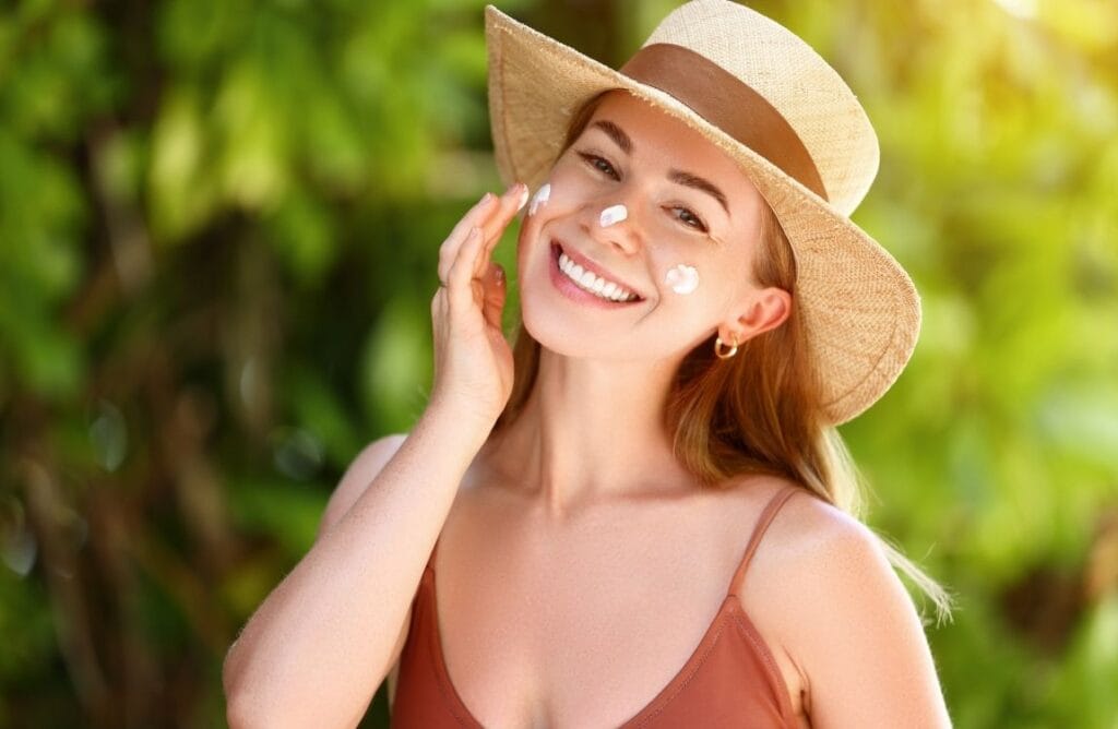 Woman applying broad-spectrum sunscreen on her face to protect skin from sun damage
