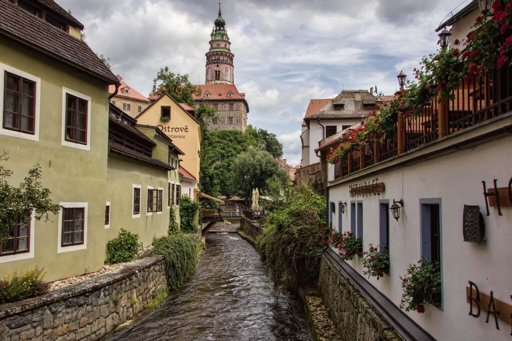 Český Krumlov castle tower rising above colorful riverside buildings and the Vltava River in the Czech Republic