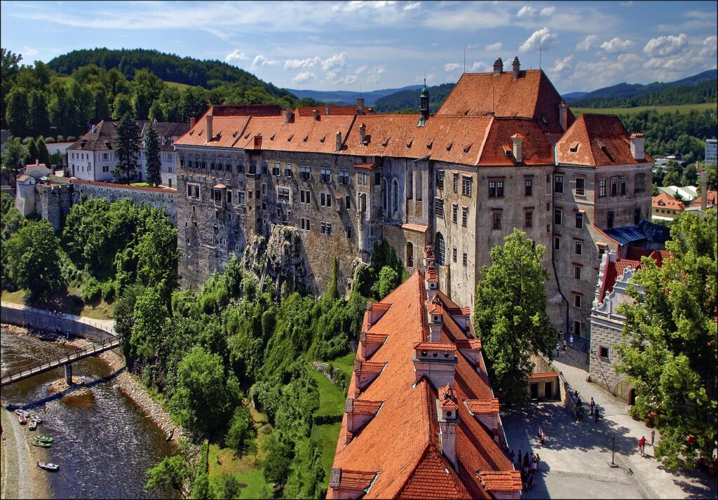 Aerial view of Český Krumlov Castle and the Vltava River surrounded by green hills, Czech Republic