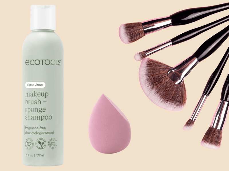 EcoTools makeup brush and sponge shampoo bottle with pink beauty blender and makeup brushes on beige background
