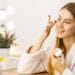 Woman applying moisturizer during minimalist skincare routine at vanity
