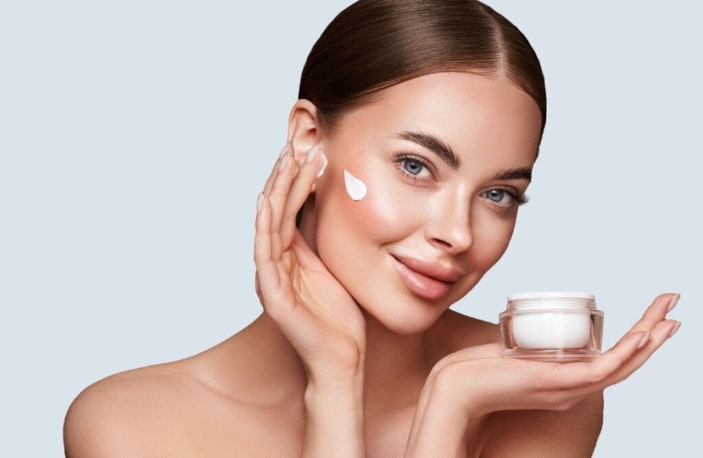Minimalist skincare woman applying cream on face for hydrated and healthy skin