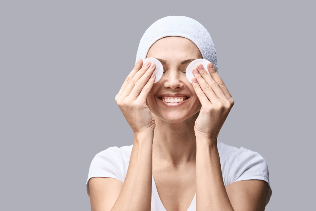 Smiling woman enjoying her skincare routine with cotton pads – clean and fresh face