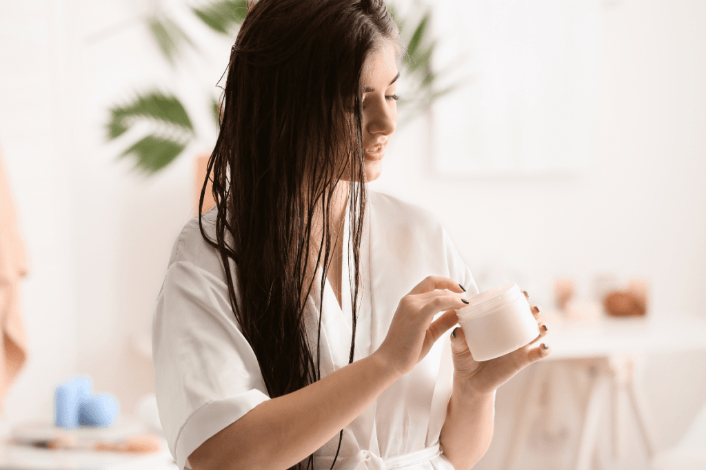 Woman in white robe applying face cream as part of her beauty self-care ritual