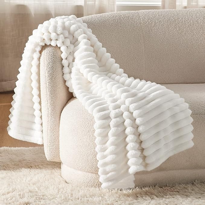 white faux fur throw blanket on a cozy cream sofa – soft feminine home decor detail