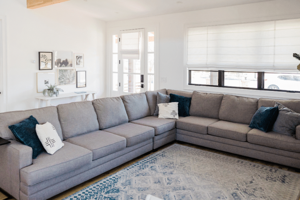 Modern living room with a large gray sectional sofa and blue accent pillows